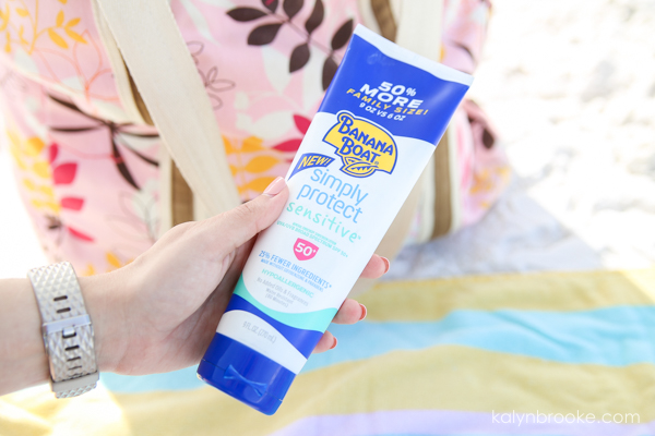 hand holding bottle of sunscreen