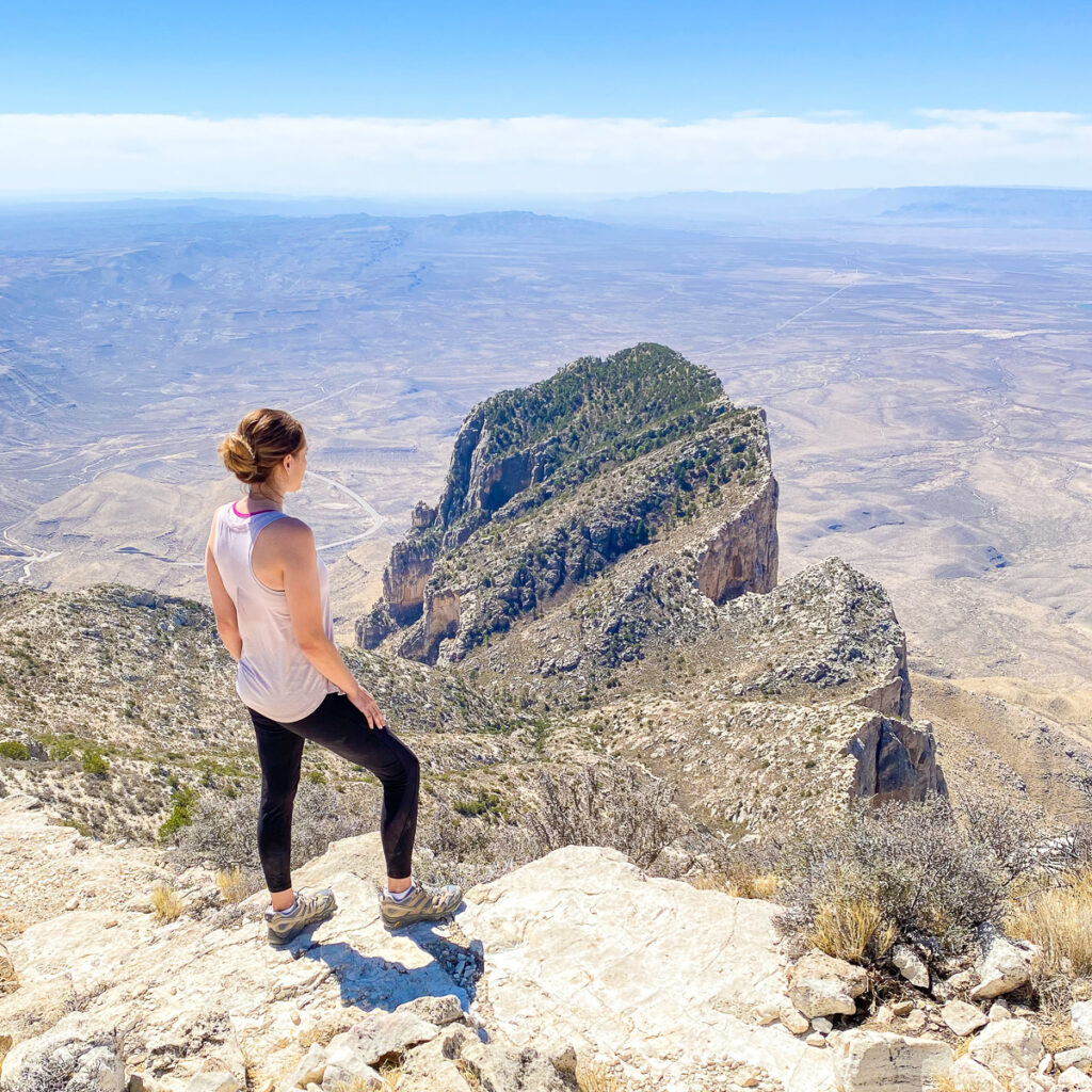 Kalyn looking down at valley from mountain peak